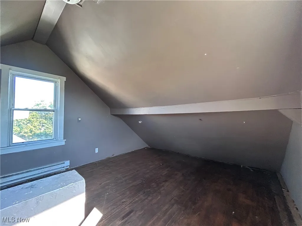 Bonus room featuring dark wood-style floors and baseboard heating