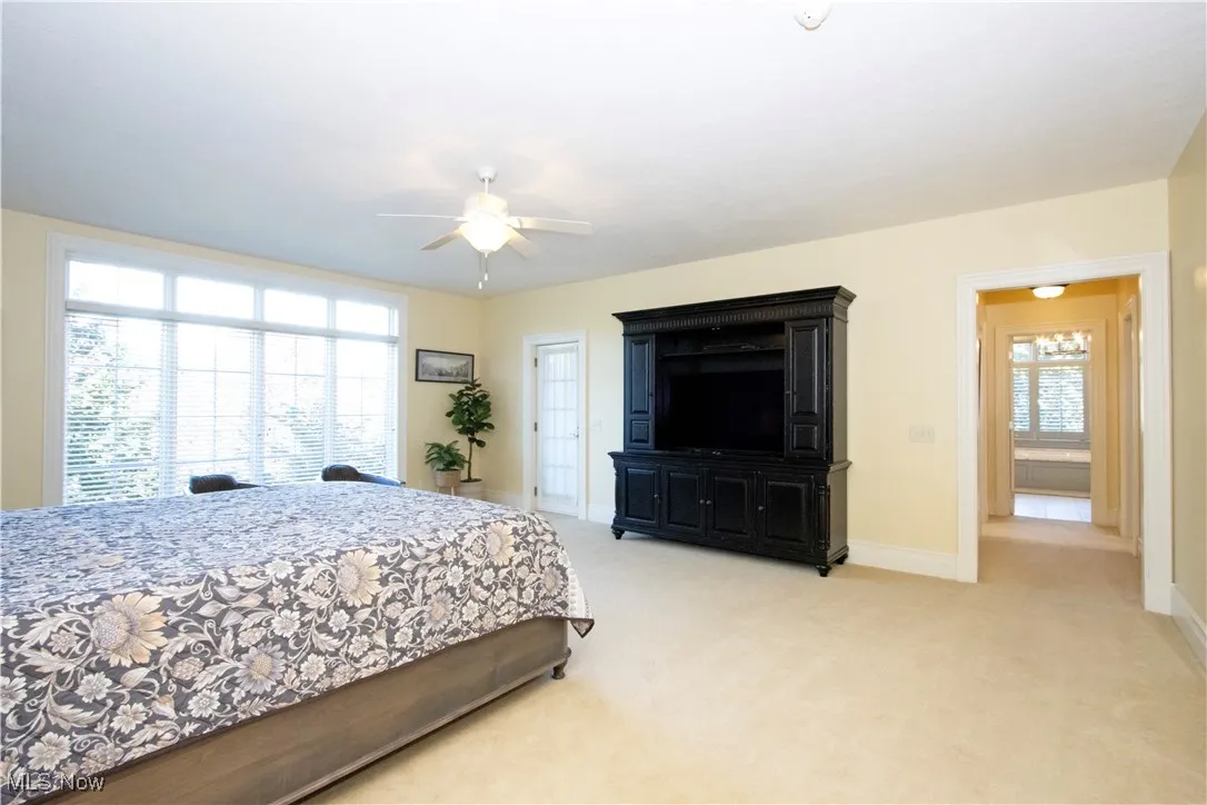 Bedroom with light carpet and a ceiling fan