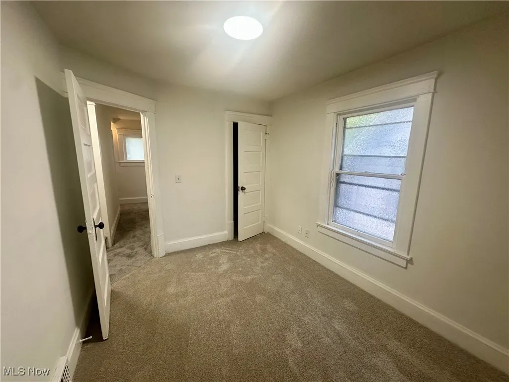Unfurnished bedroom with carpet flooring and multiple windows
