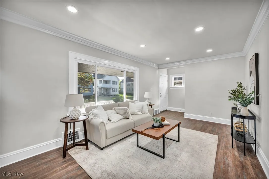 Living area with crown molding, dark wood finished floors, and recessed lighting