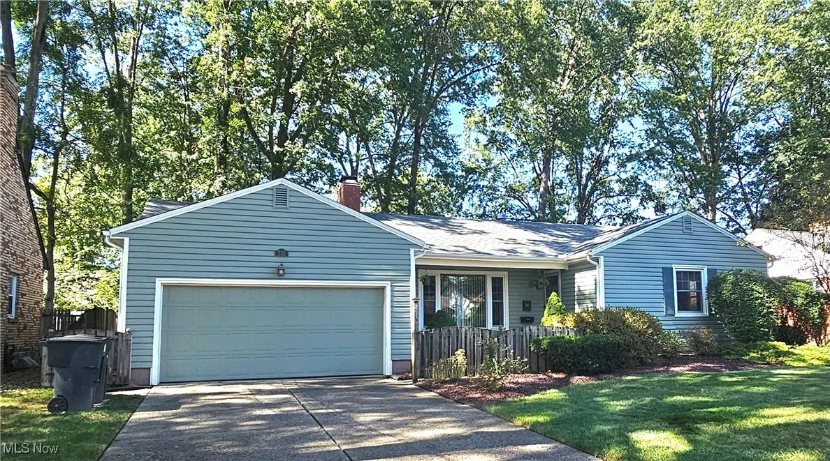 Ranch home with driveway, an attached garage and covered porch