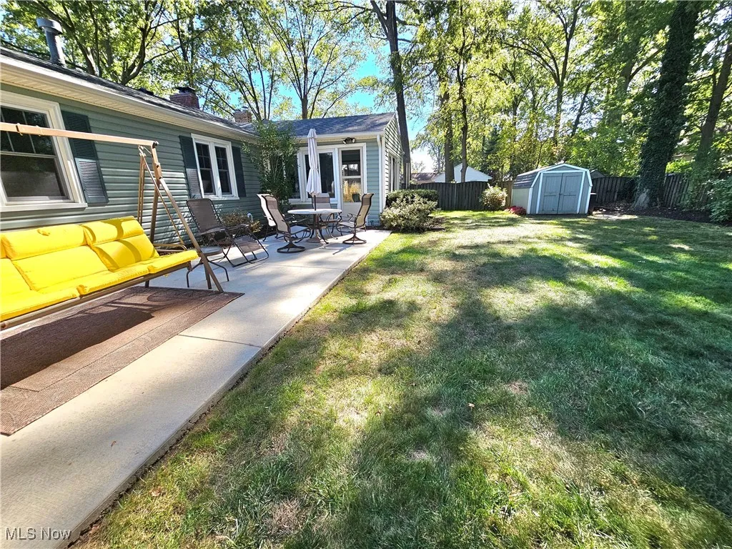 Fenced backyard with a patio and a storage unit
