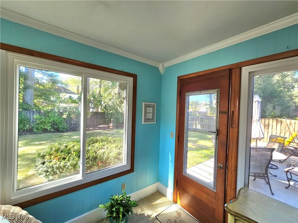 All season sunroom with ornamental molding, carpet, and healthy amount of natural light