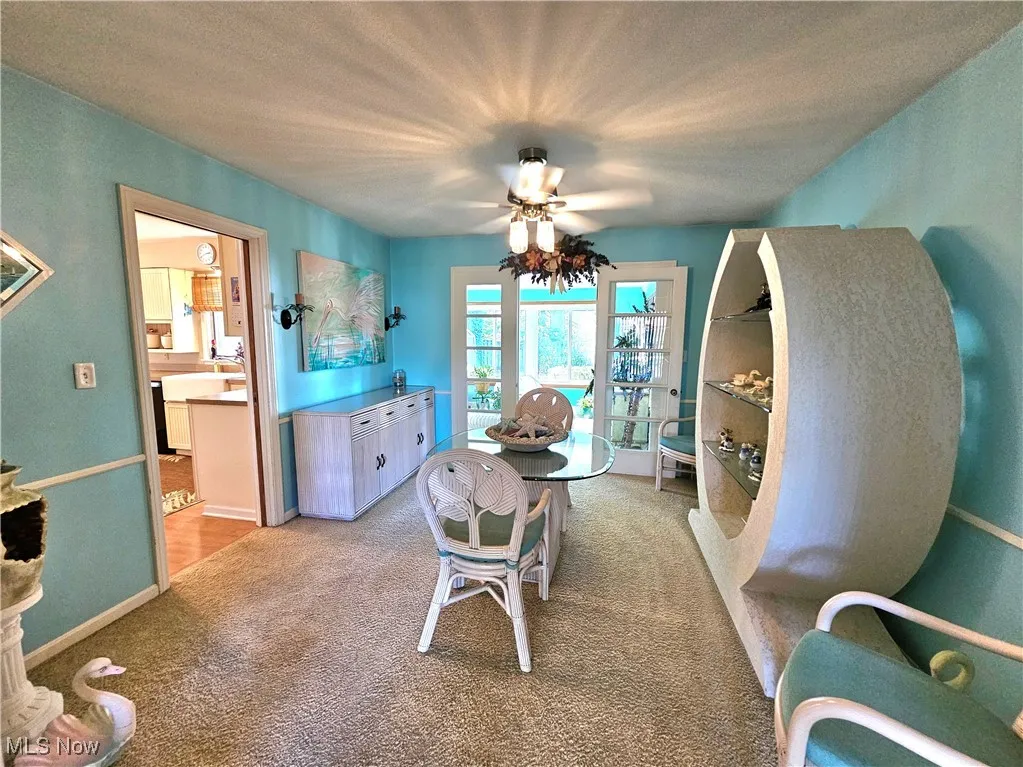 Dining room with lighted ceiling fan off the kitchen adjacent to the sunroom