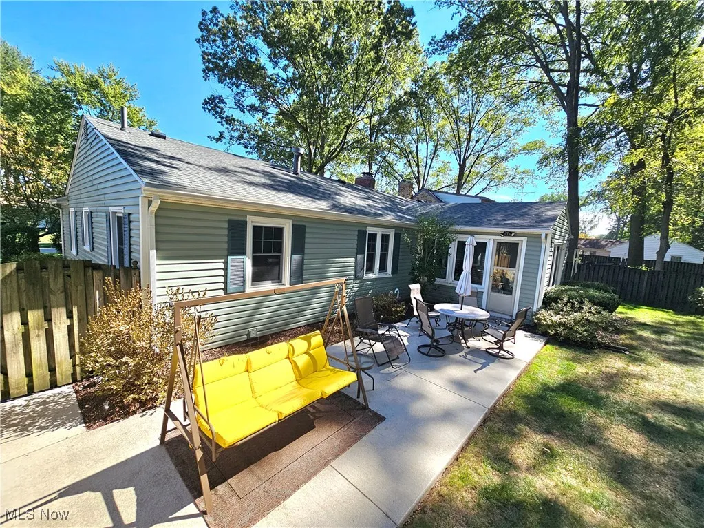 Back of property featuring a patio area, a shingled roof, and a chimney