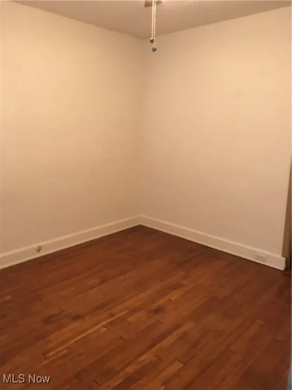 Spare room with dark wood-style flooring