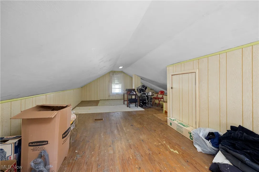 2nd floor bedroom featuring hardwood / wood-style floors, lofted ceiling, and wood walls