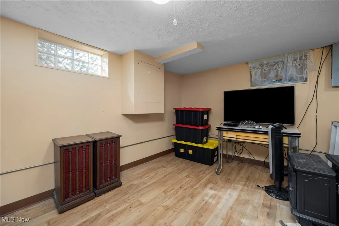 Office area/Rec room in basement  with a textured ceiling and light wood-style flooring
