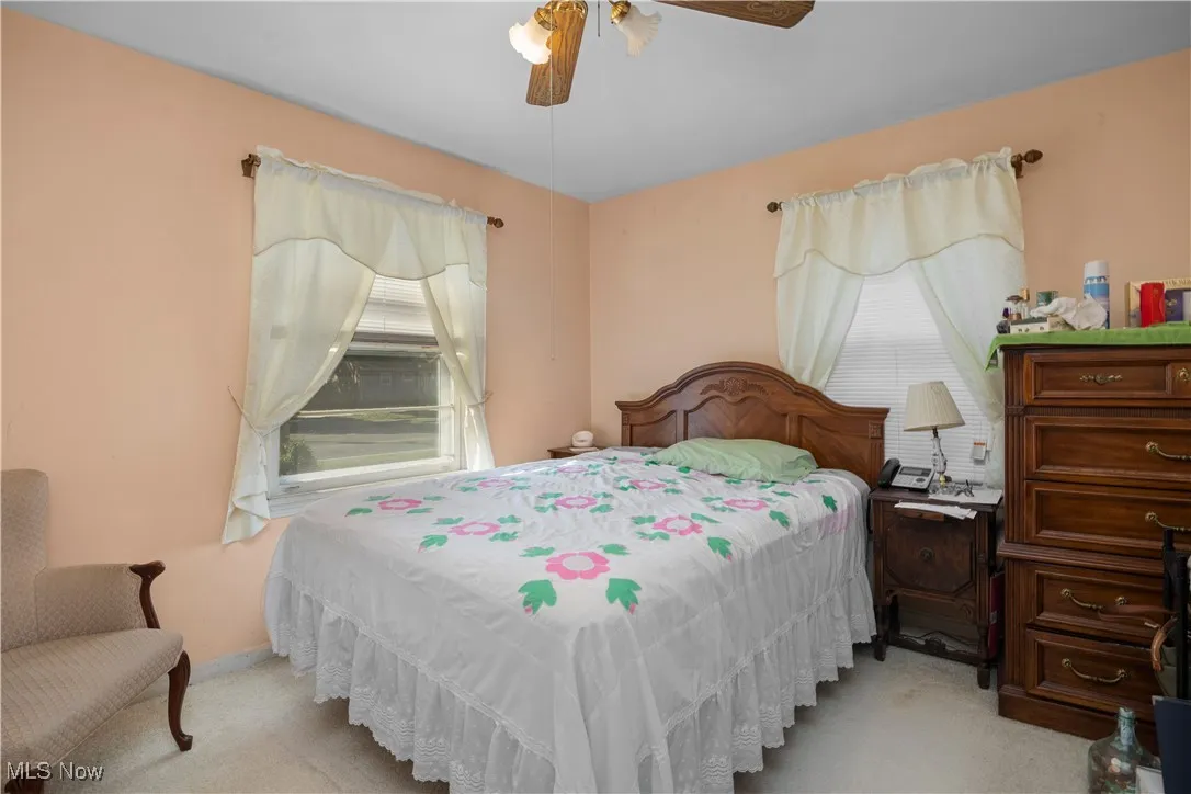 Front bedroom featuring carpet (hardwood under)and a ceiling fan
