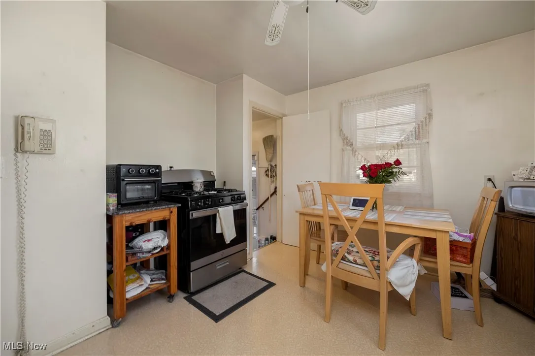 Kitchen featuring gas stove, dark countertops, and ceiling fan