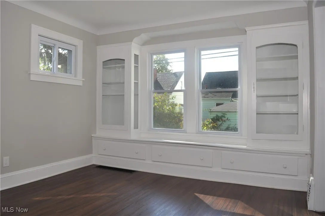 Unfurnished room with baseboards and dark wood finished floors