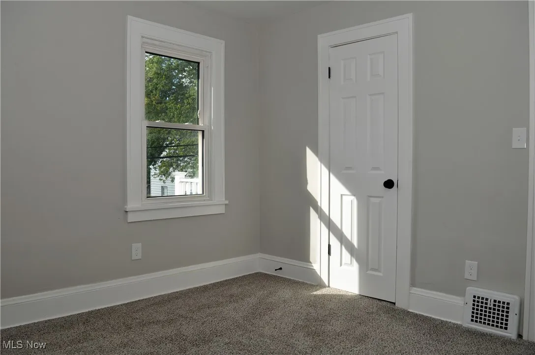 Empty room featuring baseboards and carpet floors