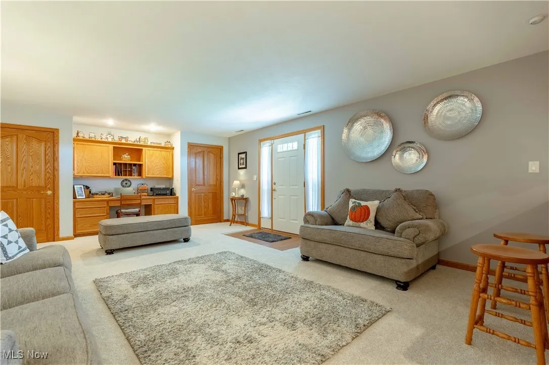 Living area with light carpet and a desk