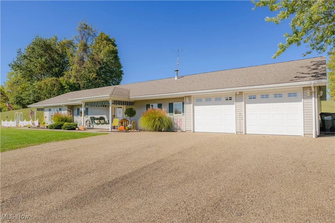 Ranch-style home with driveway, an attached garage, and a front yard