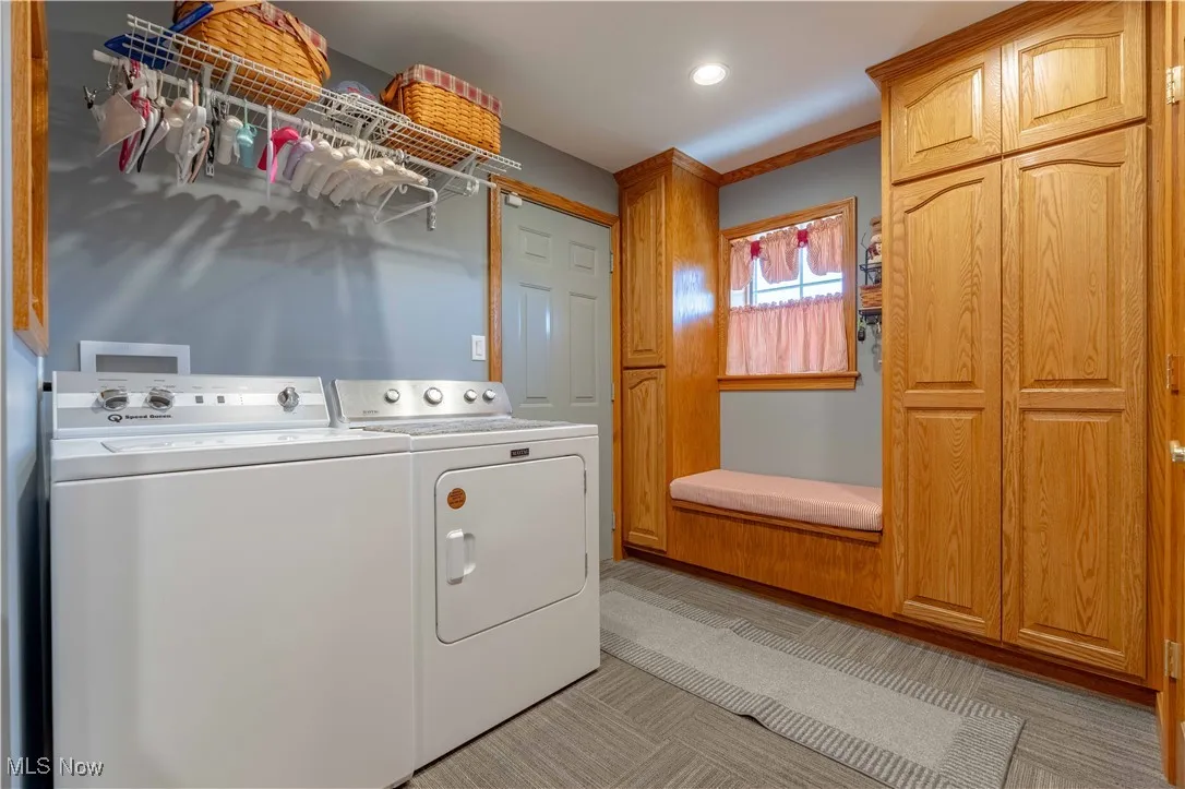 Washroom with washing machine and clothes dryer, light colored carpet, and recessed lighting
