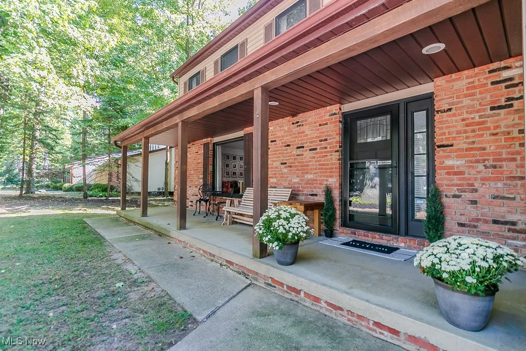 Entrance to property featuring a porch and brick siding
