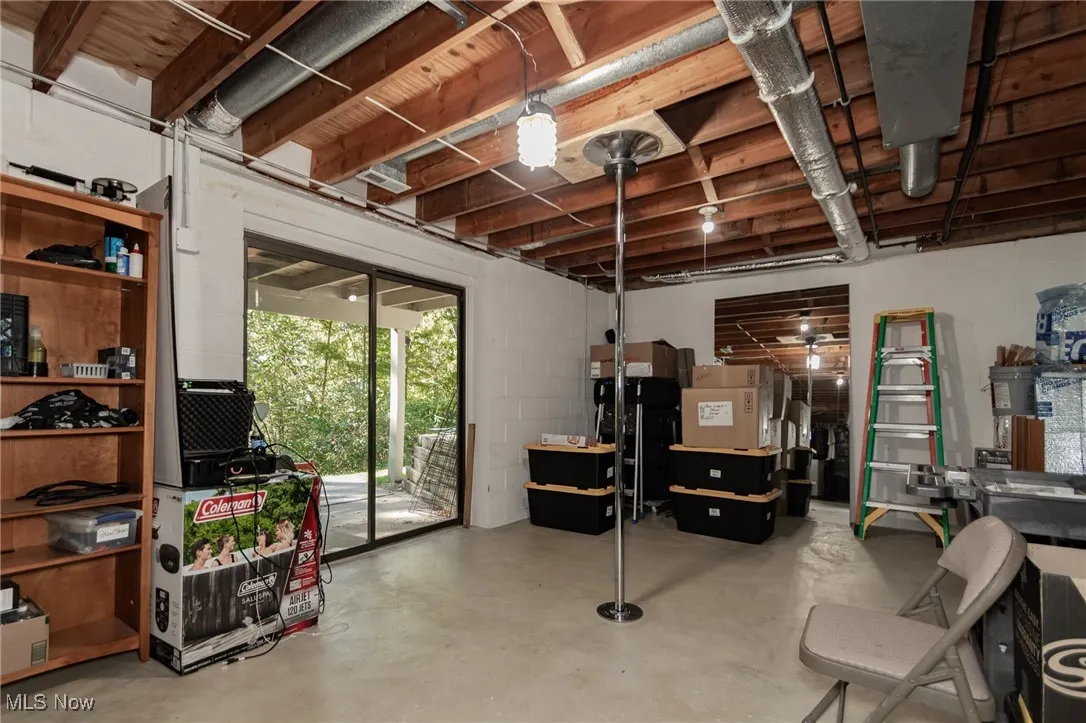 Below grade area with concrete block wall and freestanding refrigerator