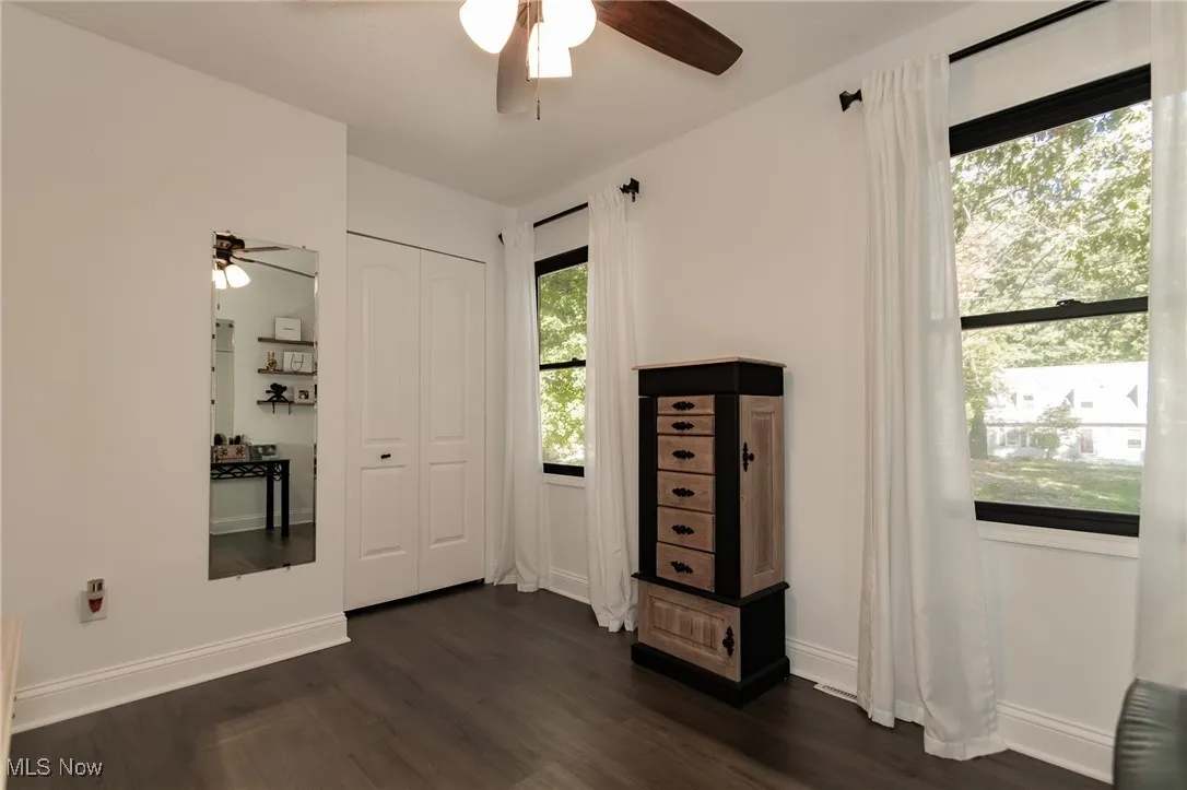 Unfurnished bedroom with dark wood finished floors, a ceiling fan, and a closet