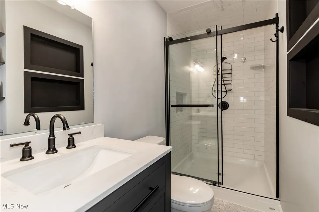 Full bath featuring a stall shower and vanity