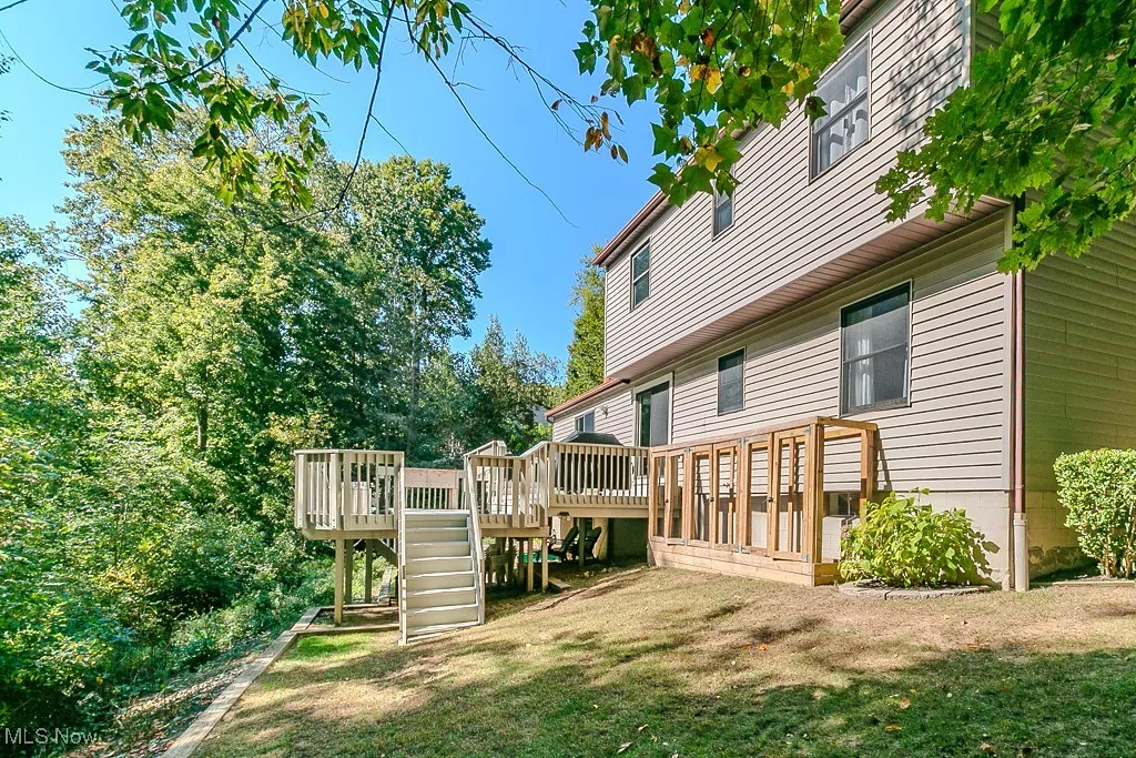Rear view of property with a deck and a yard
