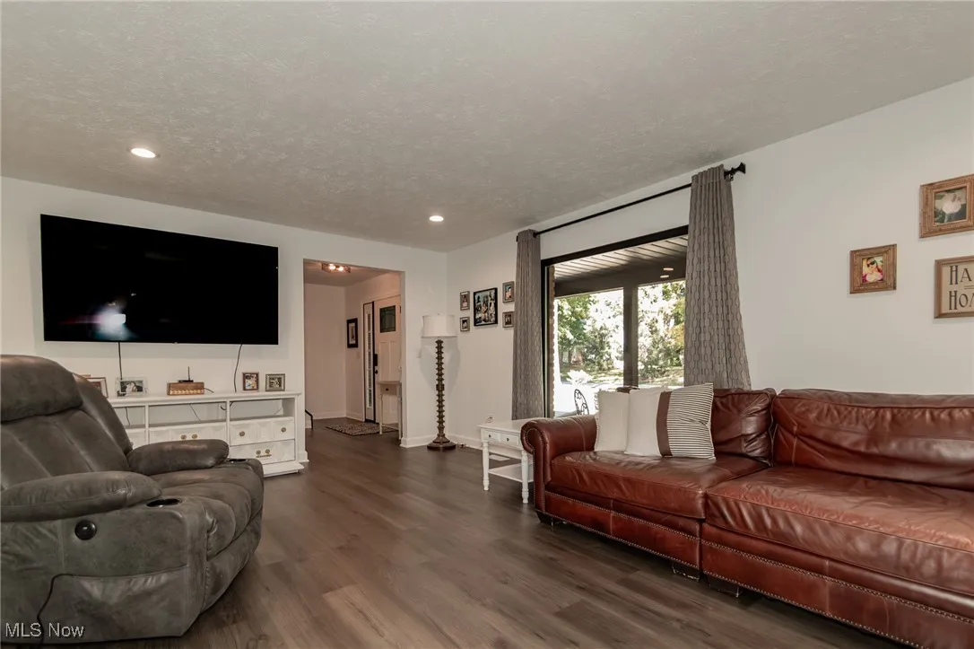 Living area featuring wood finished floors, a textured ceiling, and recessed lighting
