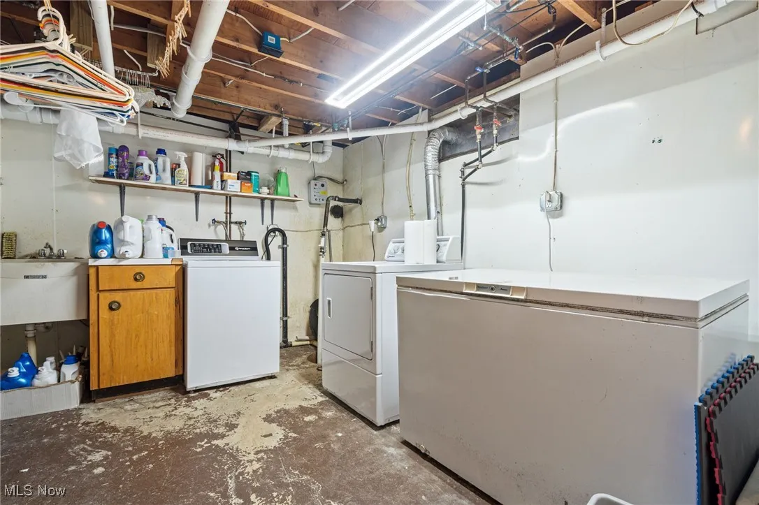 Washroom with concrete flooring and separate washer and dryer