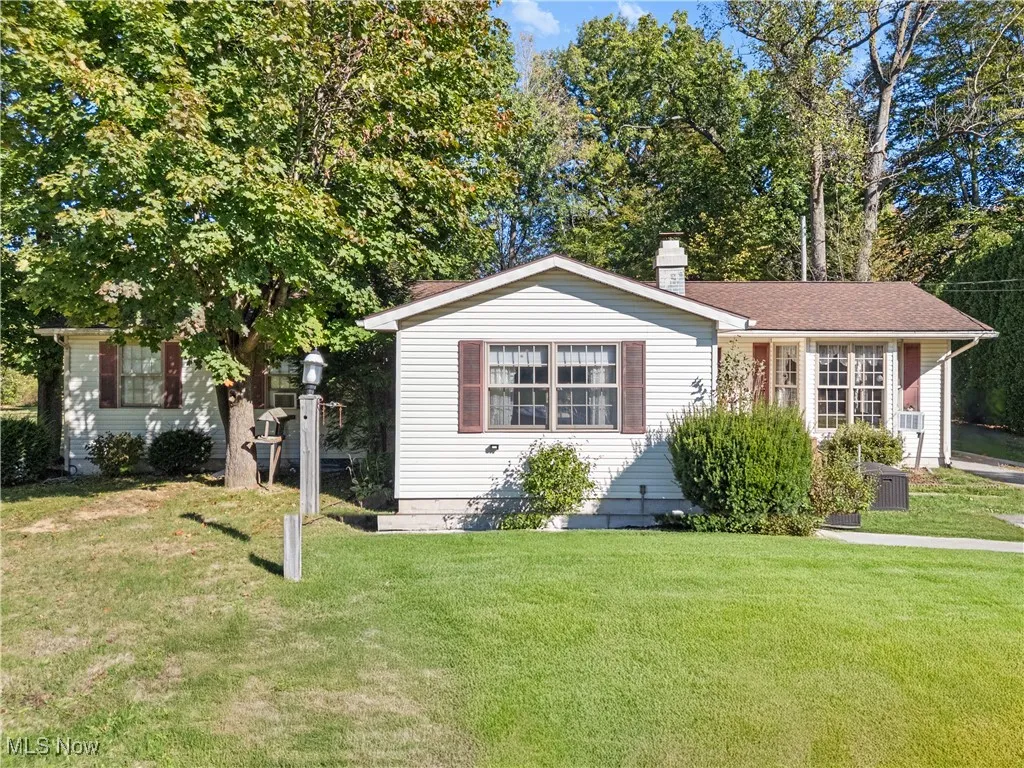 View of front of property featuring a front yard and a chimney