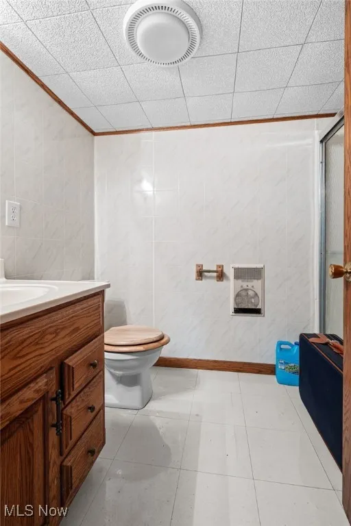 Full bathroom with vanity, a shower stall, ornamental molding, and light tile patterned floors