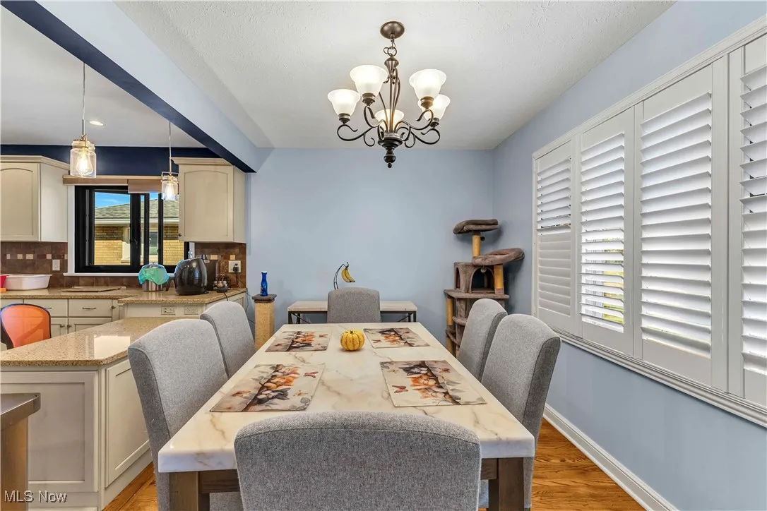 Dining space with light wood-style flooring and a chandelier