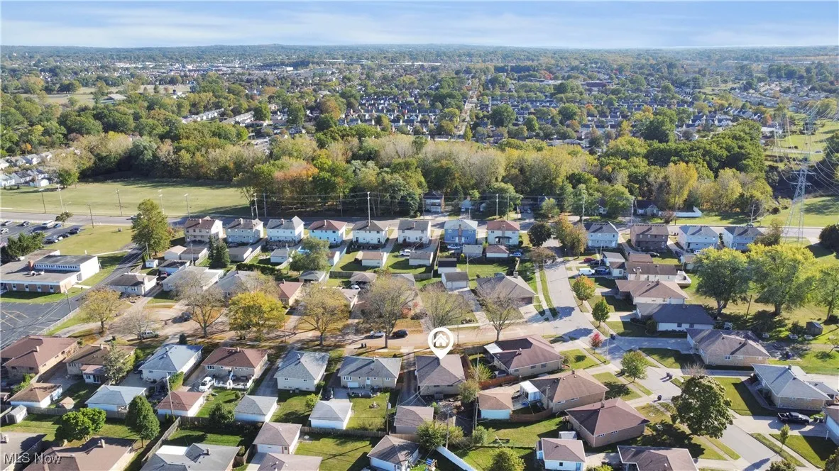Aerial view of property and surrounding area with nearby suburban area