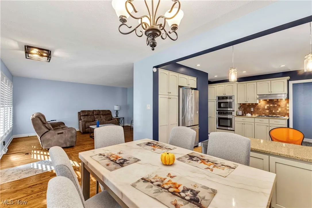 Dining room with light wood-style flooring, a chandelier, and recessed lighting