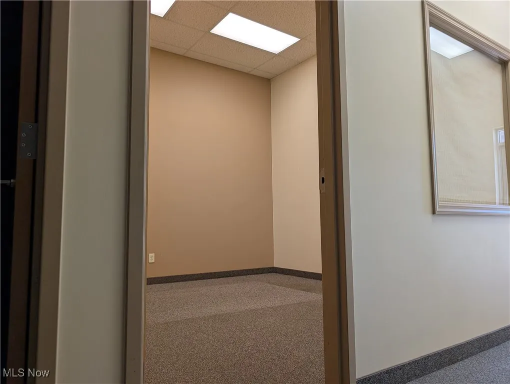 Hallway with a paneled ceiling and elevator