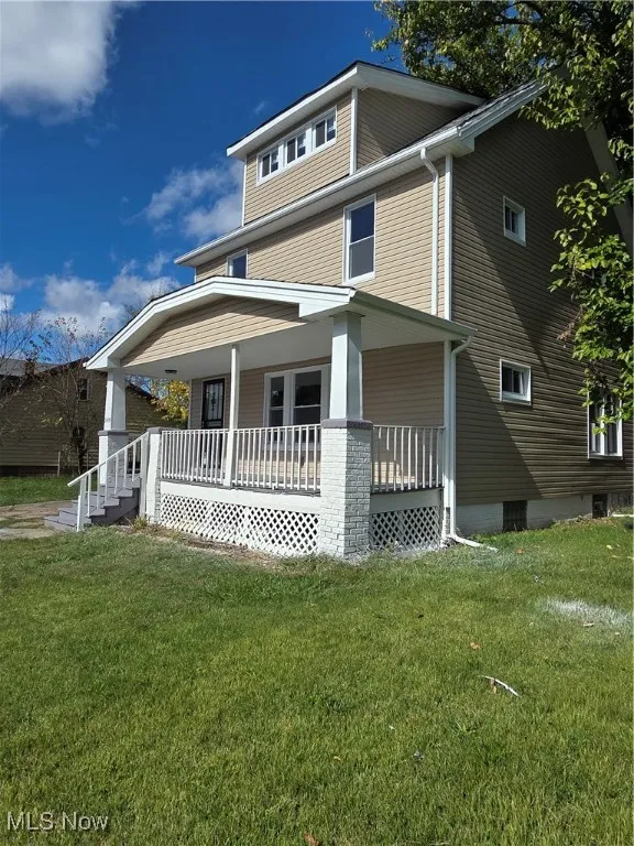 View of front facade with covered porch and a front lawn