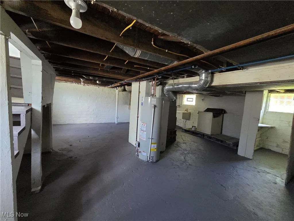 Basement with water heater and a sink
