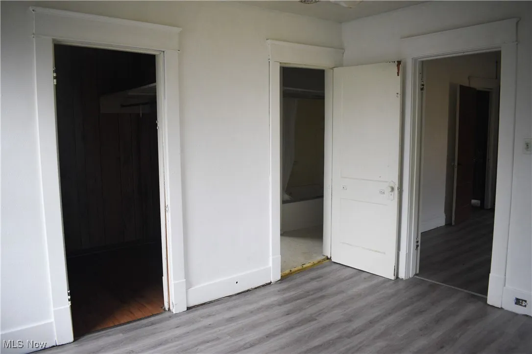 Unfurnished bedroom with wood finished floors and a closet