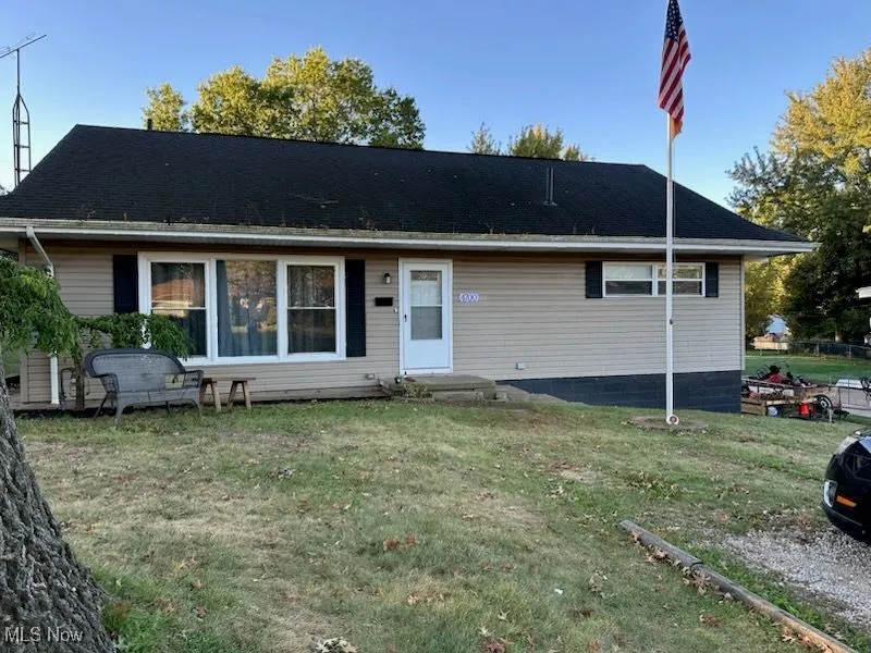 View of front facade with a front yard, entry steps, and roof with shingles