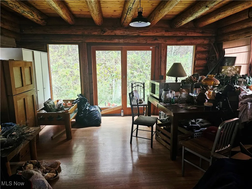 Dining area with plenty of natural light, a wood ceiling with exposed beams, and hardwood / wood-style floors