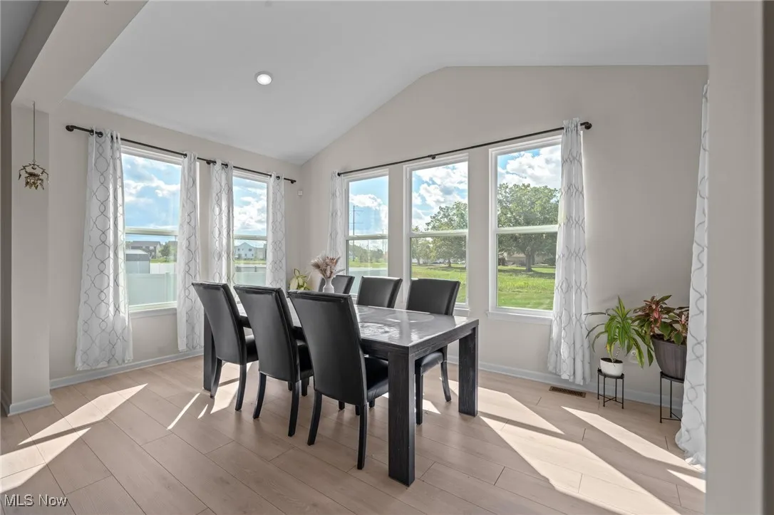 Dining area featuring lofted ceiling, light wood-style floors, and recessed lighting