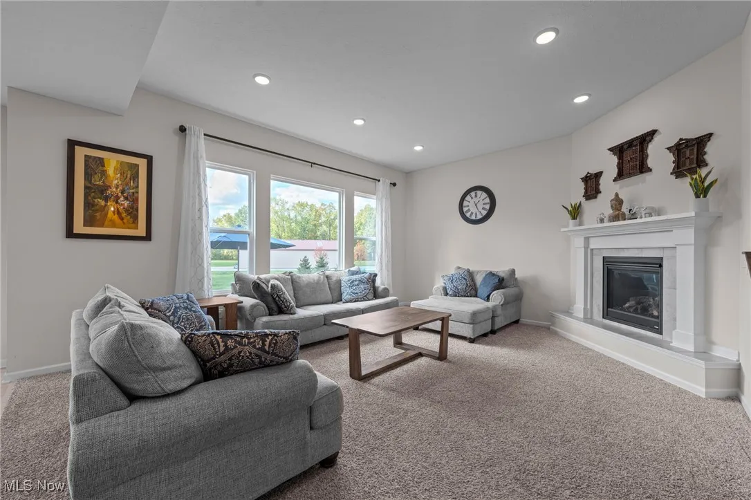 Carpeted living room with a fireplace and recessed lighting