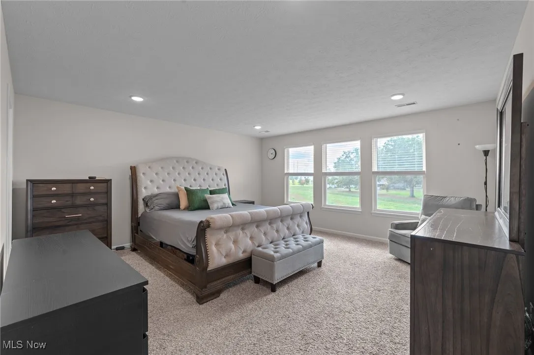 Bedroom with light colored carpet and recessed lighting