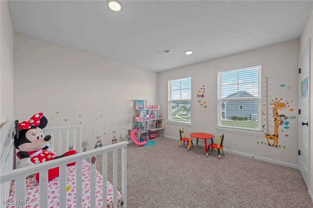Bedroom with carpet flooring, recessed lighting, and a nursery area
