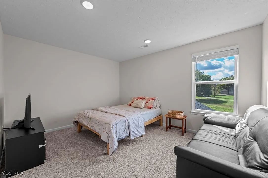 Bedroom with light colored carpet and recessed lighting
