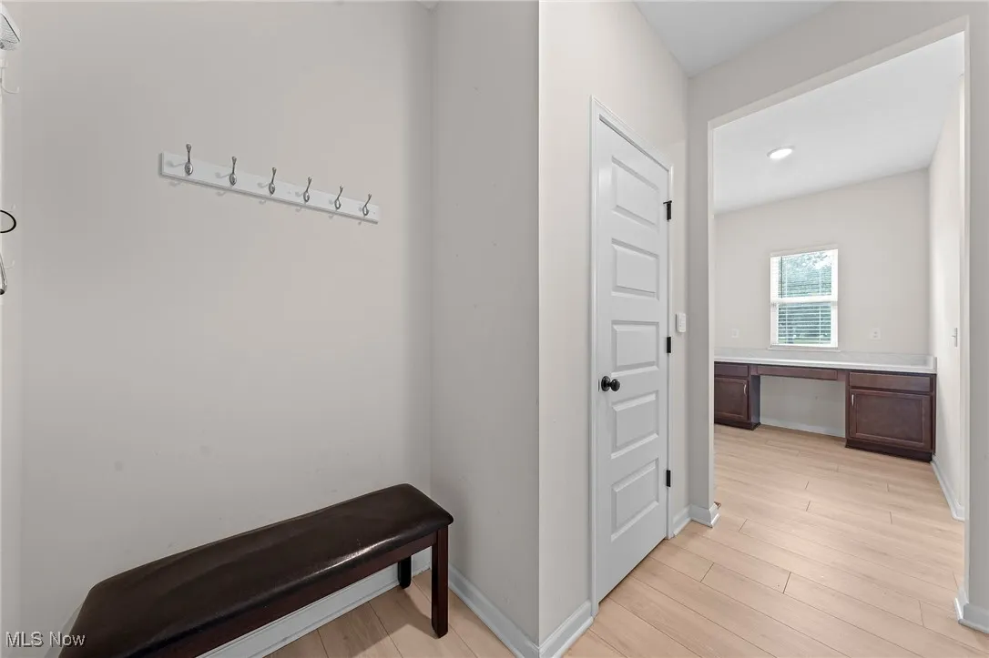 Hallway with an office area and light wood-style flooring