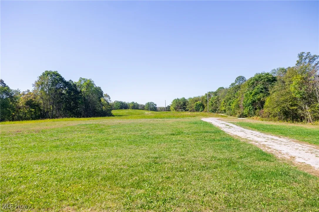 Surrounding community featuring a yard, a view of rural / pastoral area, and a wooded view