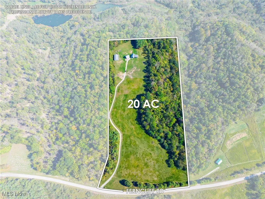Aerial view of property's location with property parcel outlined and a heavily wooded area