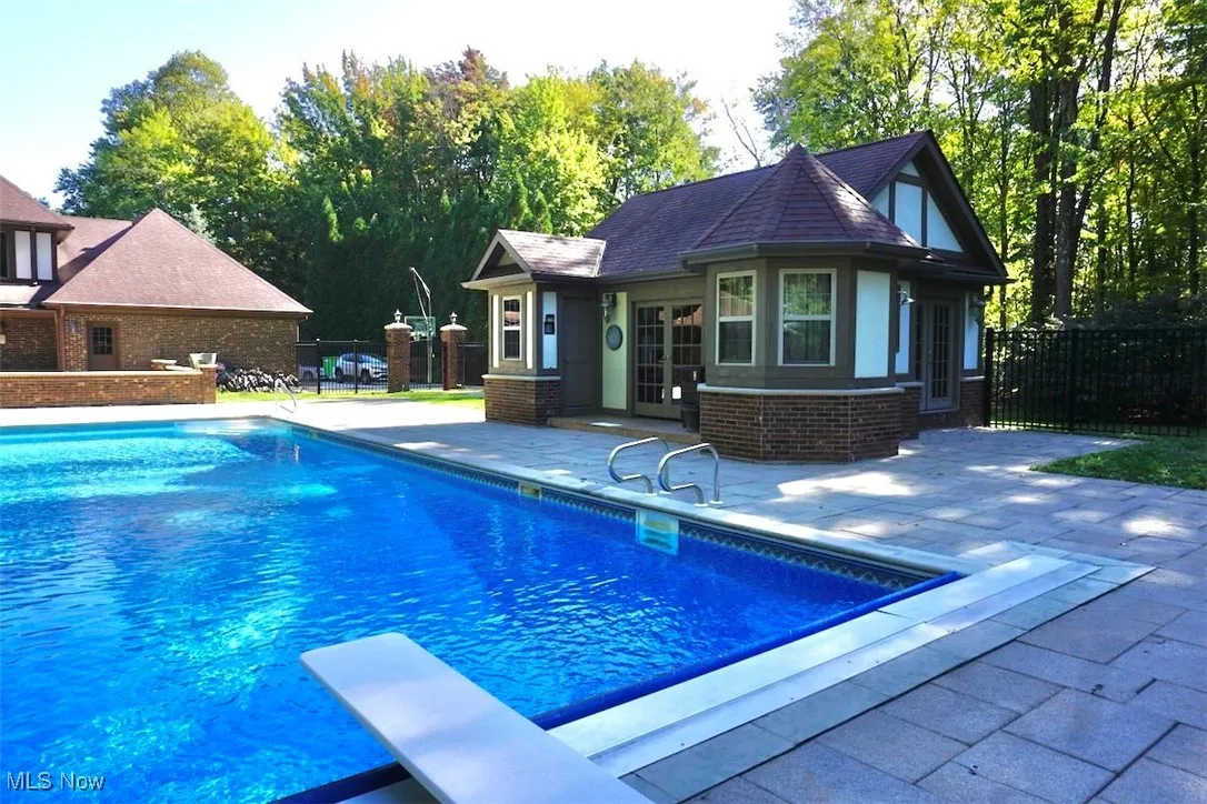 View of pool with a patio area, a diving board, and french doors