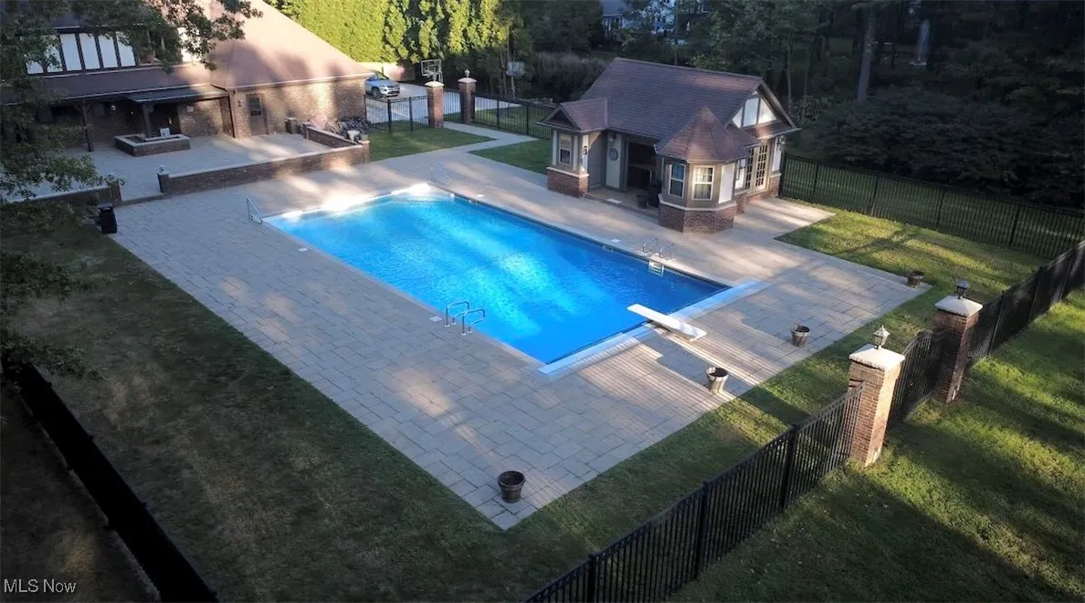 View of swimming pool with a fenced backyard, a patio area, an exterior structure, an outbuilding, and a diving board