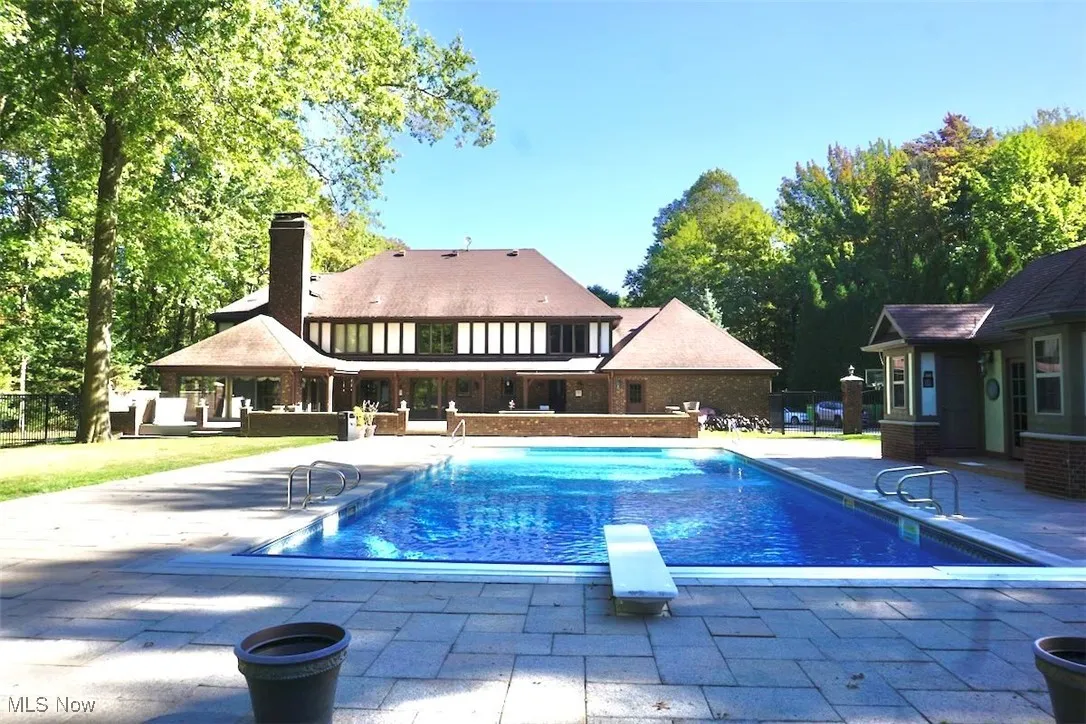 Outdoor pool with a diving board and a patio area