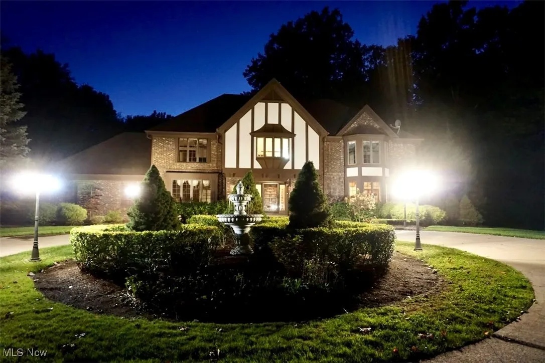 English style home with brick siding and concrete driveway
