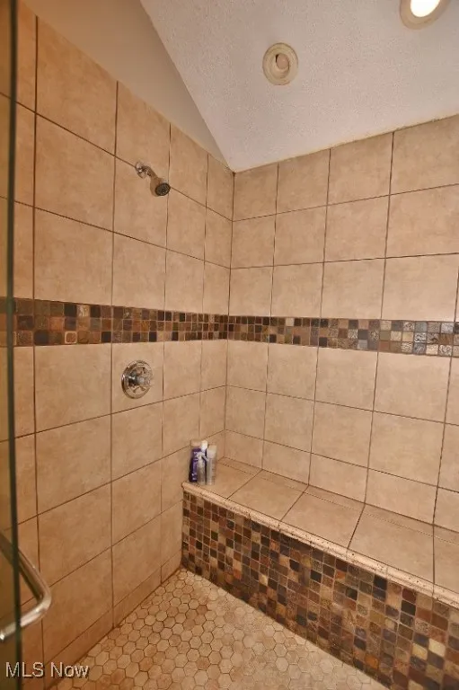 This custom tiled shower features a sitting area and double shower heads